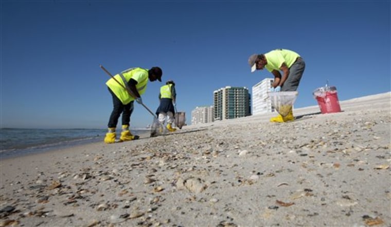 Oil spill workers continue the process of cleaning tar balls and oil from the beaches of Orange Beach, Ala., Tuesday, Nov. 9, 2010. A BP official said deep cleaning operations would continue along the coast for some time.